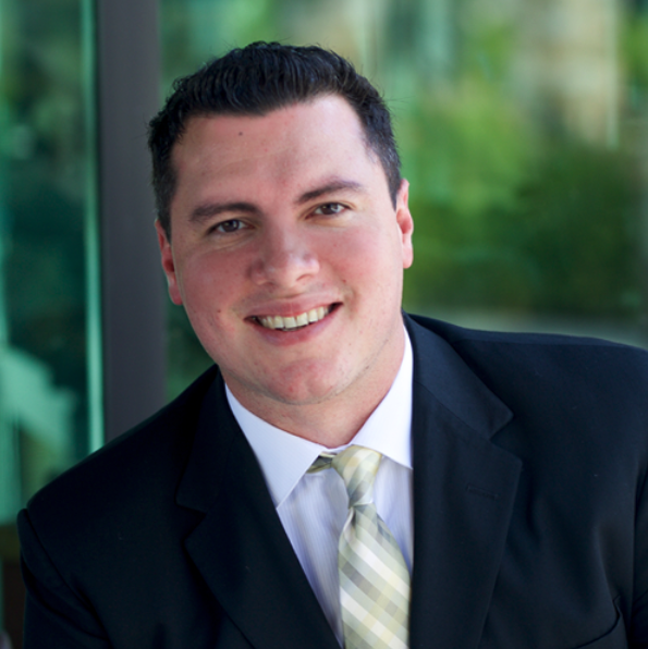 A man in a suit smiling after a non-surgical pain treatment.