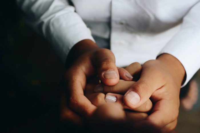 A close up of hands holding each other.