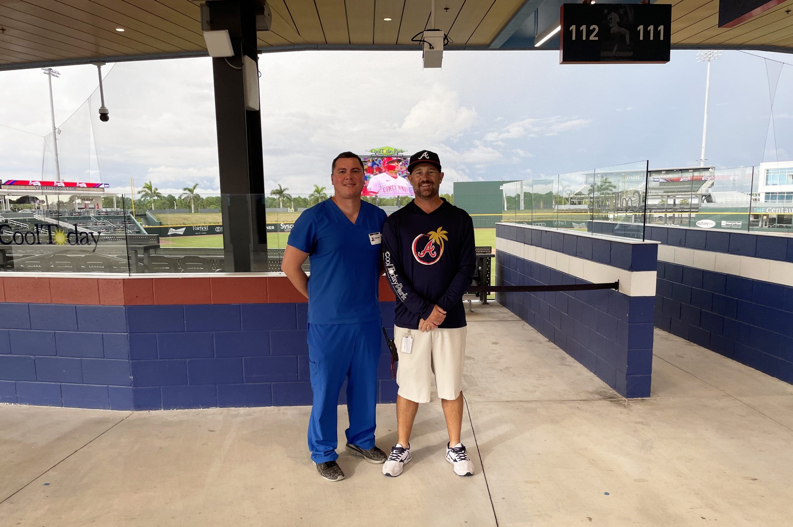 Two men standing in a baseball field.