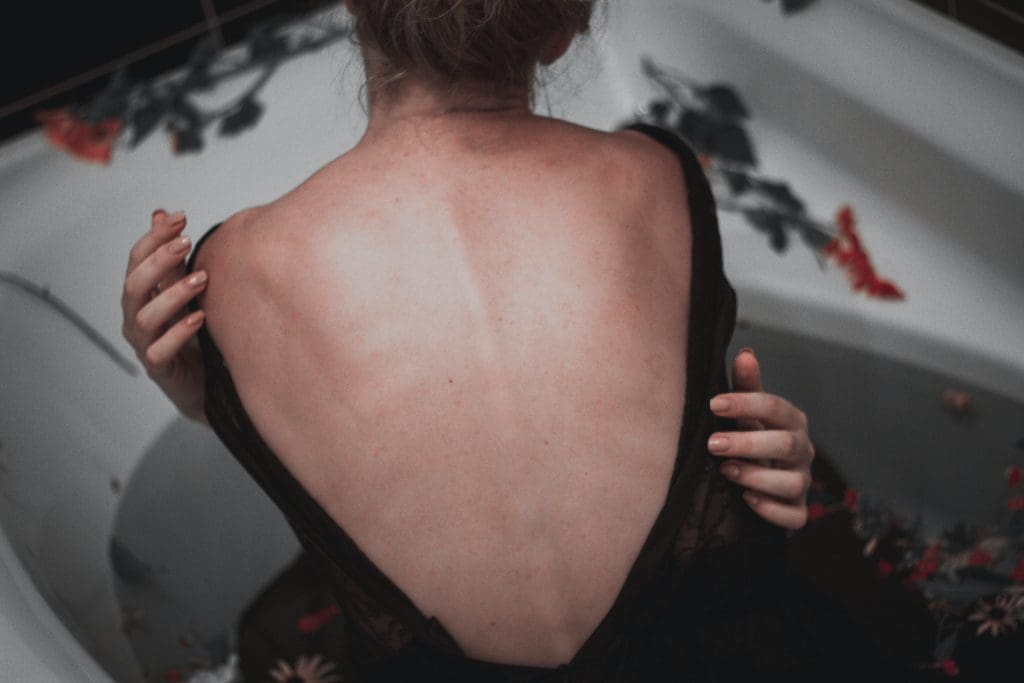 A woman holding her back to her dress.