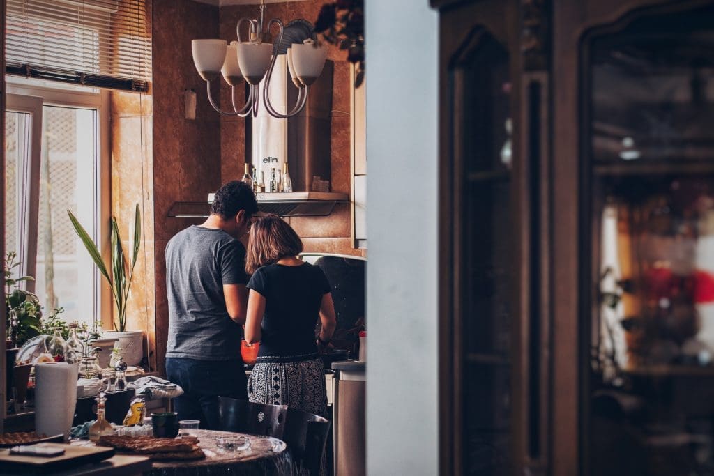 A man and woman in a kitchen.