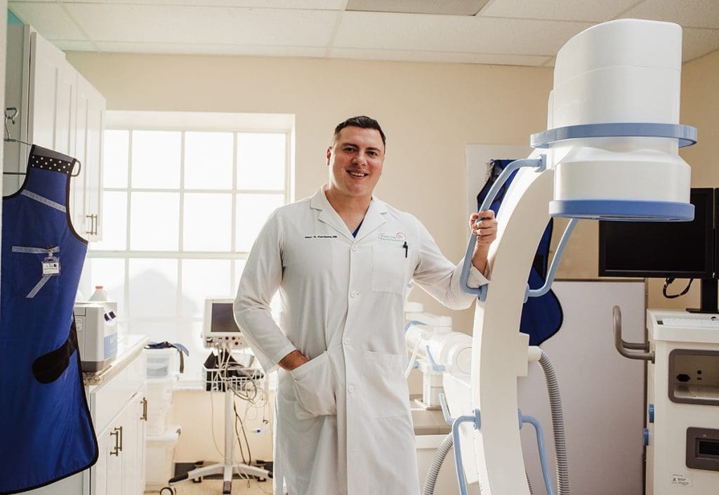 A man in a white coat specializing in non-surgical pain treatment.