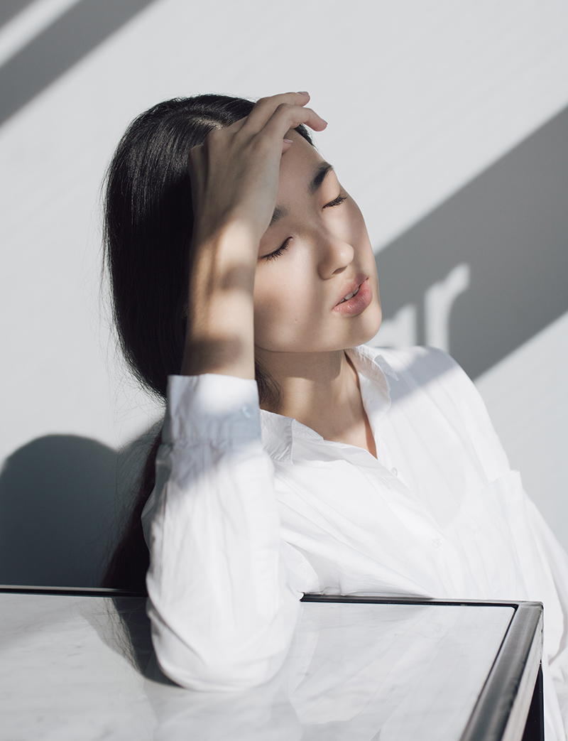 A woman with her hand on her head.