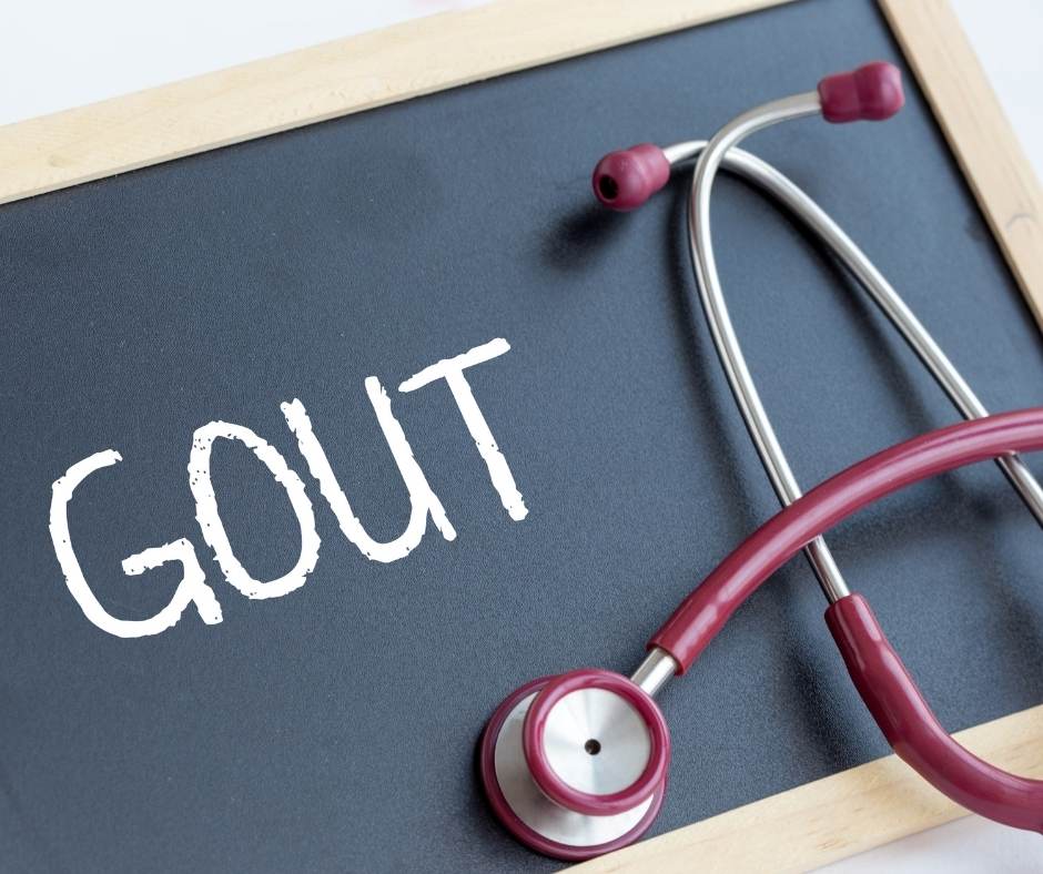 A stethoscope next to a chalkboard with the word gout written on it.